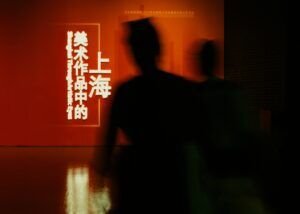 Siluetas de personas en una exhibición artística sobre Shanghái.