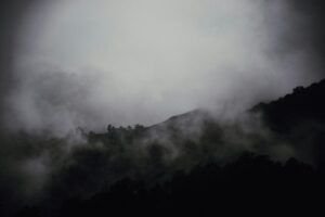Montañas envueltas en niebla y nubes oscuras